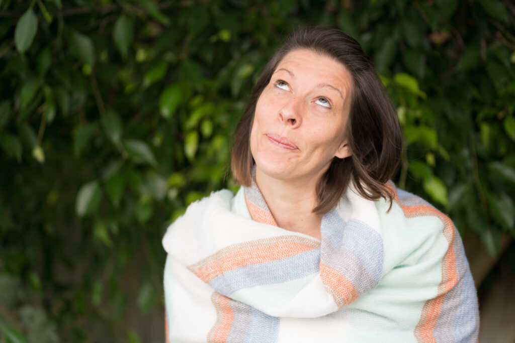 A picture of Amy Brandon looking up to the sky in shawl.